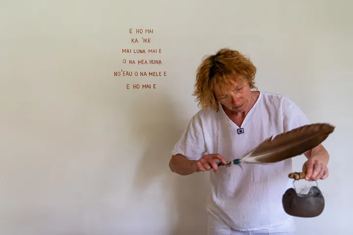 Ritueller Moment mit Feder und Klanginstrument im Raum von Loving Hands.